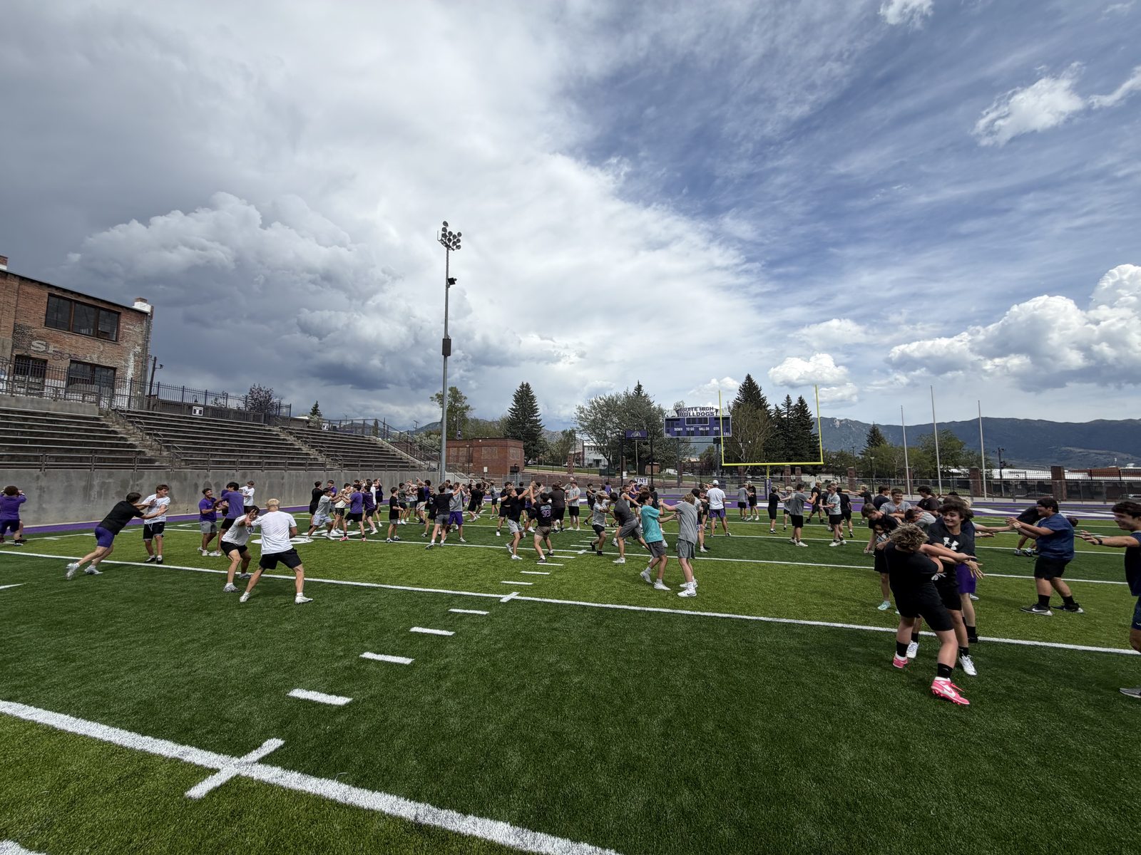 Butte High Bulldogs players running drills with Tackle Montana
