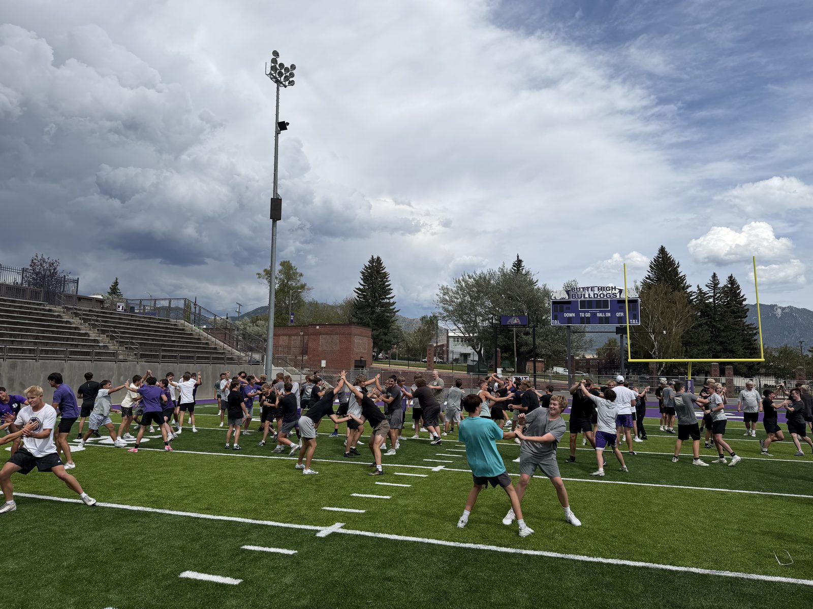 Butte High Bulldogs players warming up during a Tackle Montana session