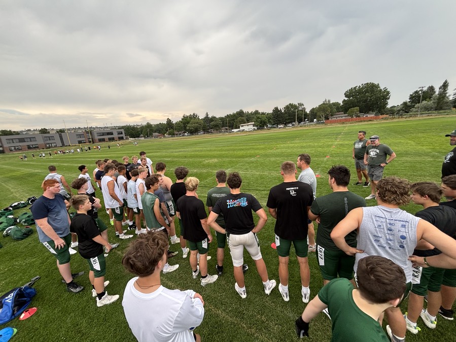 Billings Central players huddled around their coach during a training session